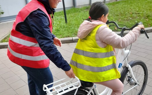 leerkracht duwt kind op fiets
