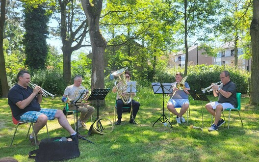 De koperen blaasinstrumenten geven een orkest voor ons in de tuin .