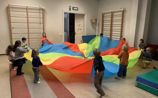 De kleuters spelen met de parachute