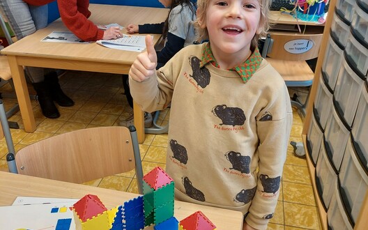 kind achter een tafel - heeft een kasteel gebouwd