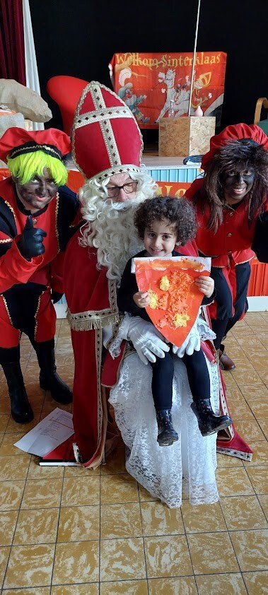 kind zit op de schoot van Sinterklaas