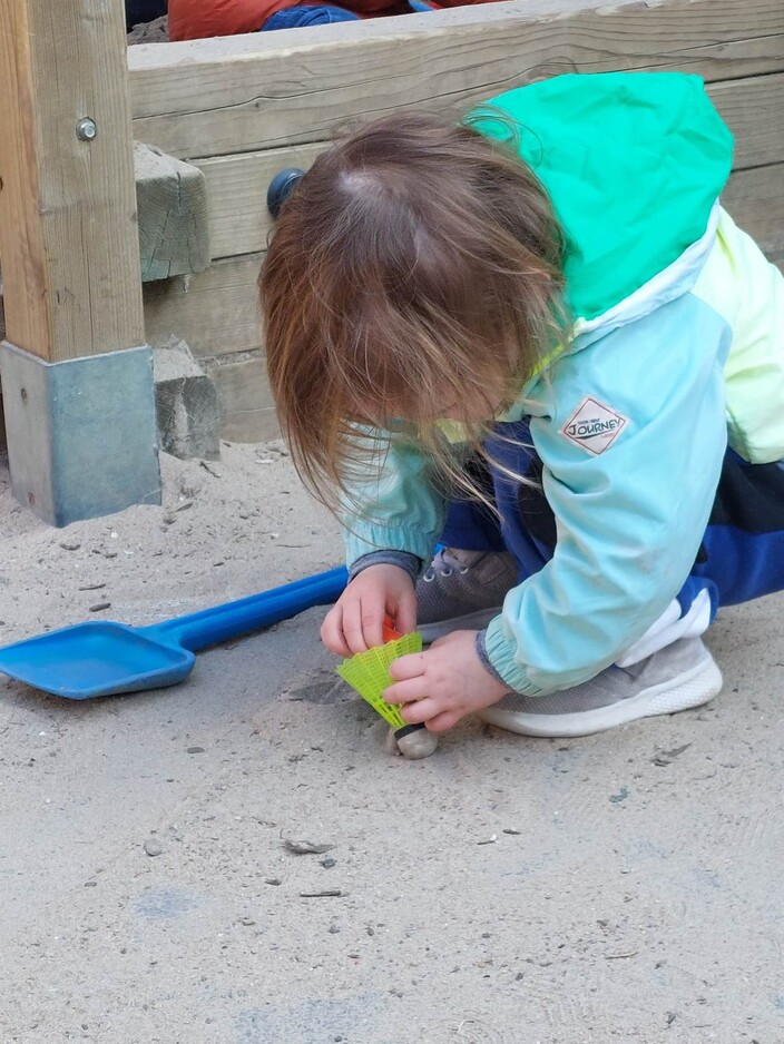 Moïra geniet van haar spel naast de zandbak