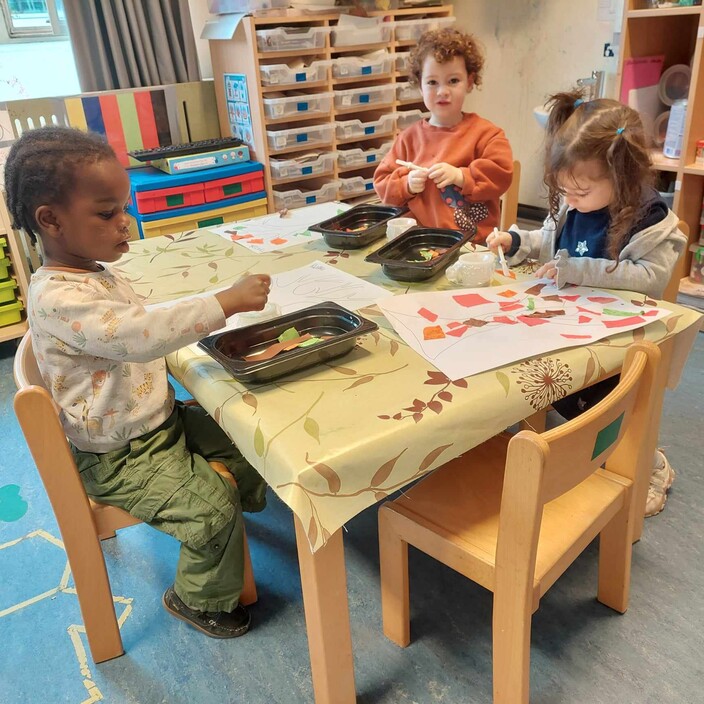 Kwaku, Tirzah en Melanie scheuren en plakken een boom in de herfst