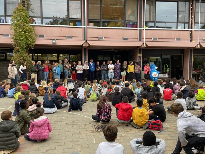 Kinderen op de speelplaats voor de dag van de leerkracht