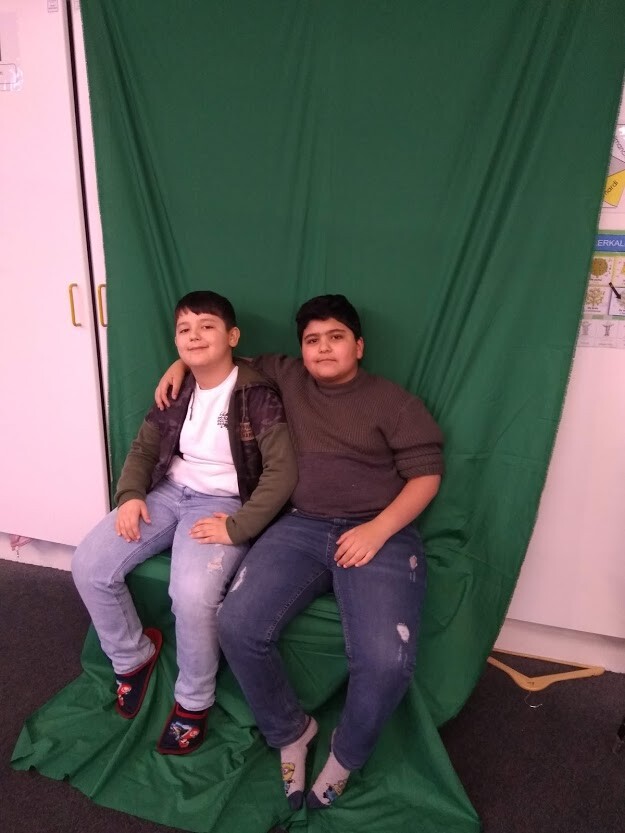 Ismail en Harun poseren voor een green screen