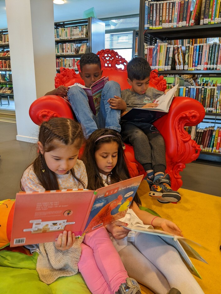 Asma, Desislava, Assaad en Shadi lezen in de bibliotheek.