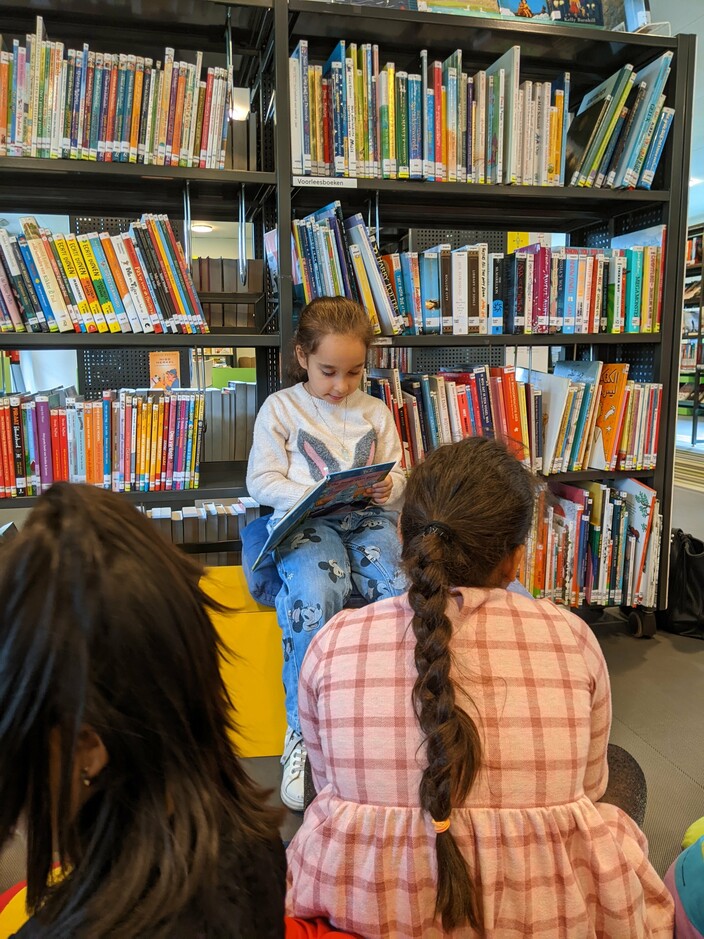 Narin leest in de bibliotheek.