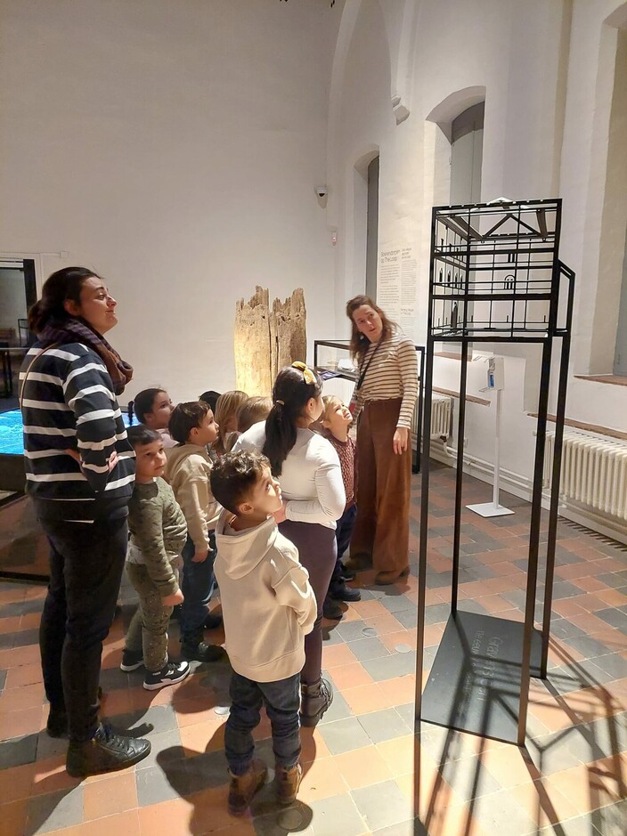 kinderen staan in groep in een museum
