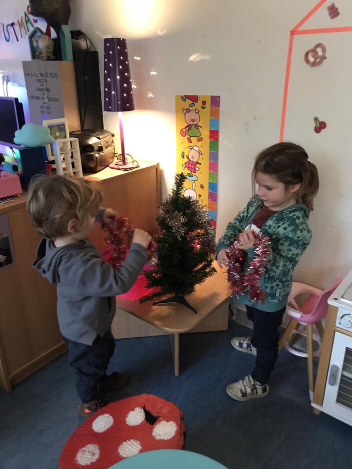 De kerstboom versieren in de poppenhoek.