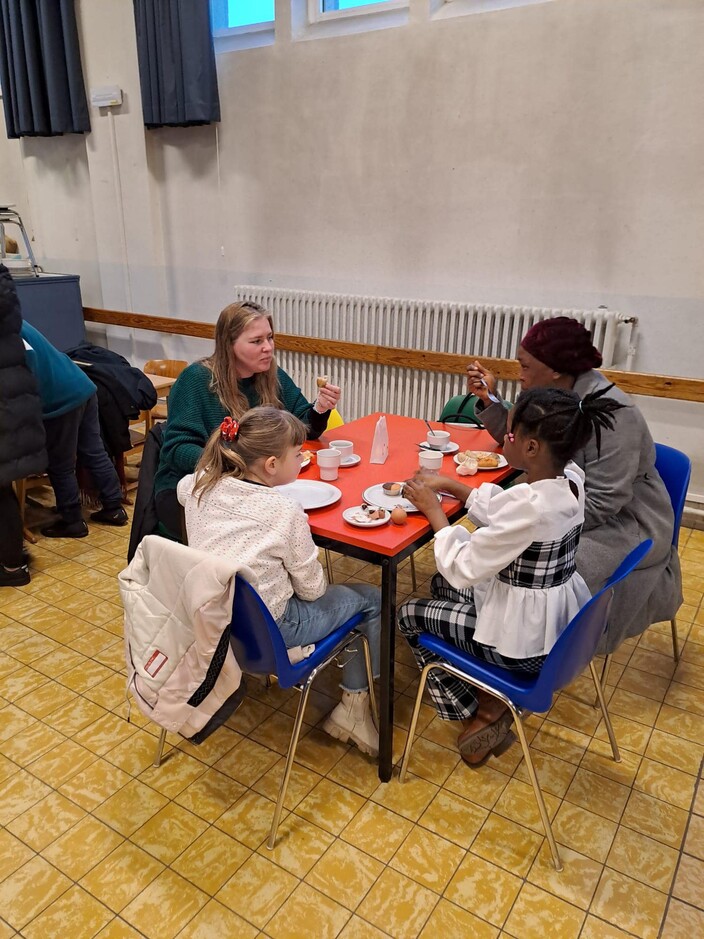 Drie kinderen eten samen aan een tafel.