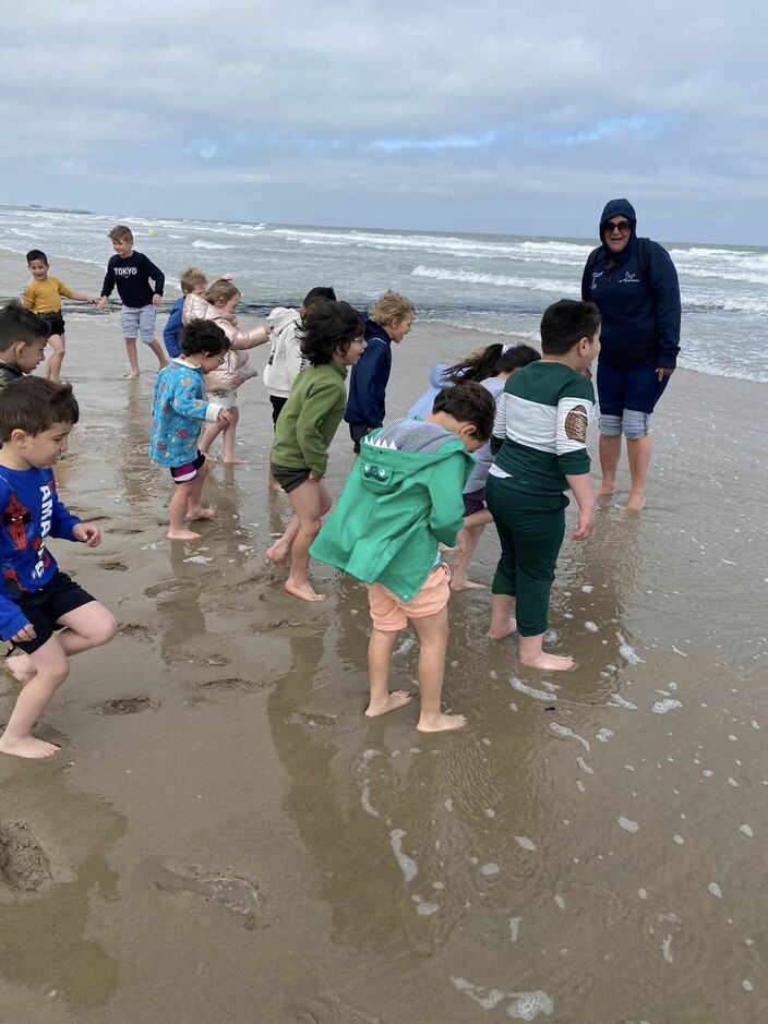 kinderen staan met de voeten in zeewater
