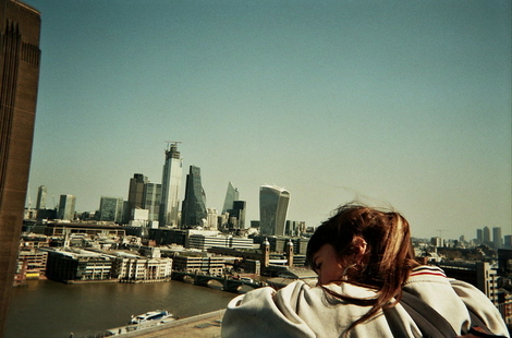 Meisje kijkt over de railing en ziet de skyline van Londen