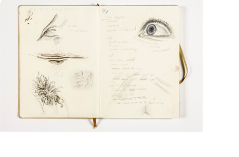 Een schetsboek met een tekening van een hand en een oog